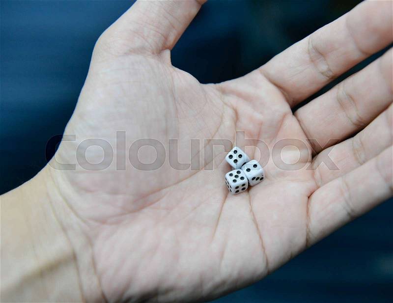 Three dice in the human hand, stock photo