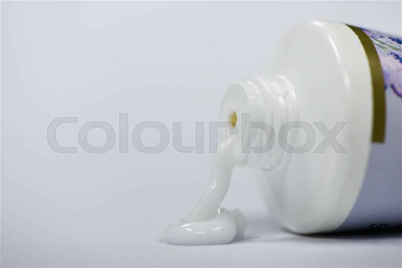 White lotion cream flowing from the bottle, stock photo