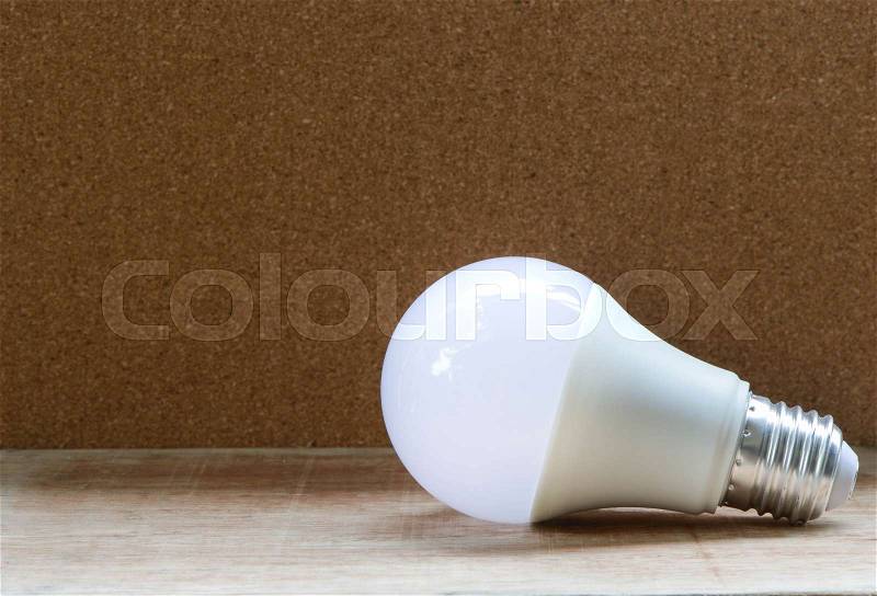 LED bulb with lighting is on the wooden table, stock photo