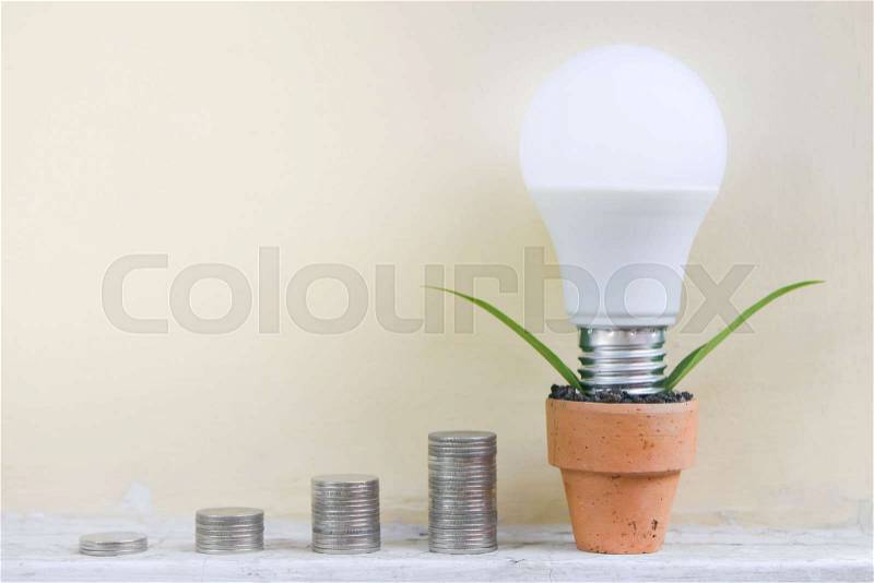 LED bulb grow up from the pot and coins stracks for saving energy concept, stock photo