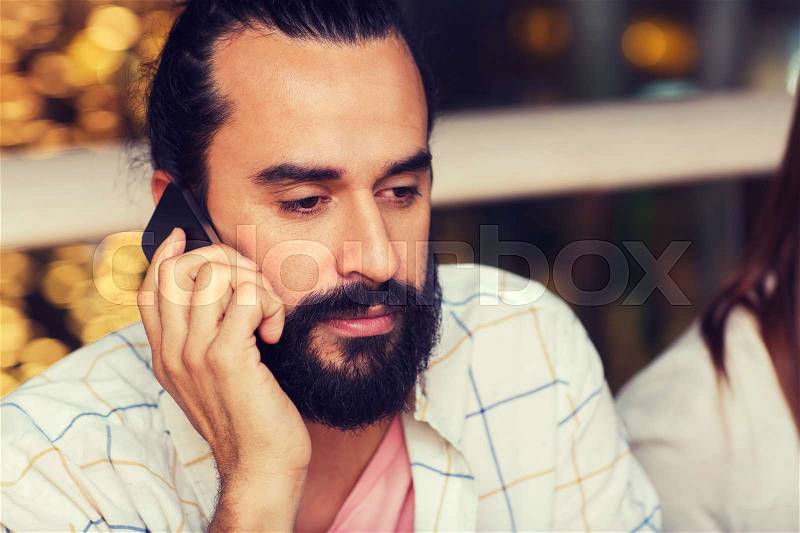 Leisure, technology, lifestyle, communication and people concept - sad man calling on smartphone at restaurant, stock photo