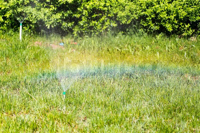Rainbow from a water fountain in the nature , stock photo