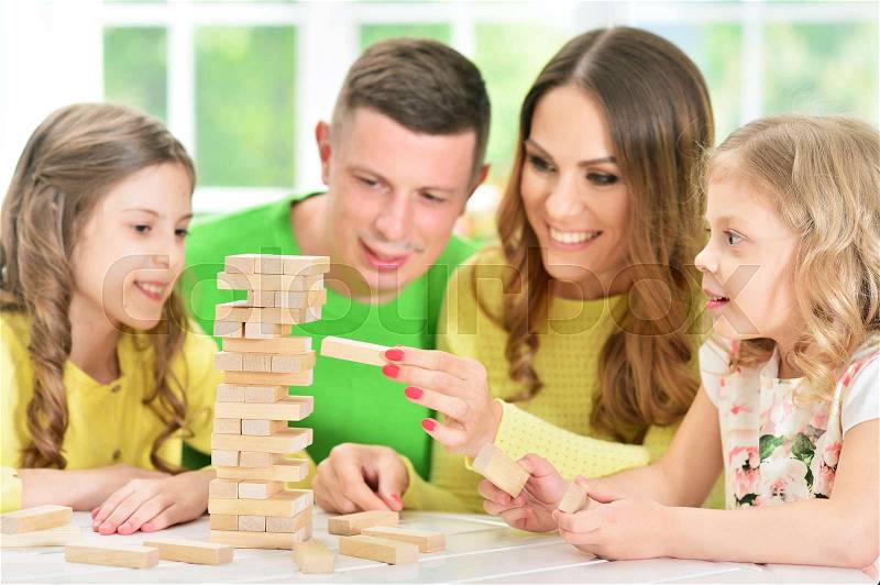 Portrait of a happy family playing with blocks together, stock photo