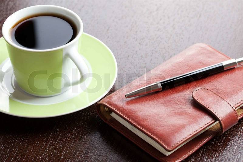Photo shot of pen on diary and coffee mug, stock photo