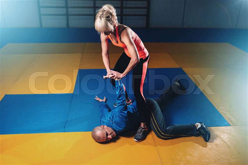 Woman fights with man, self-defense technique, self defense workout in gym, martial art, stock photo