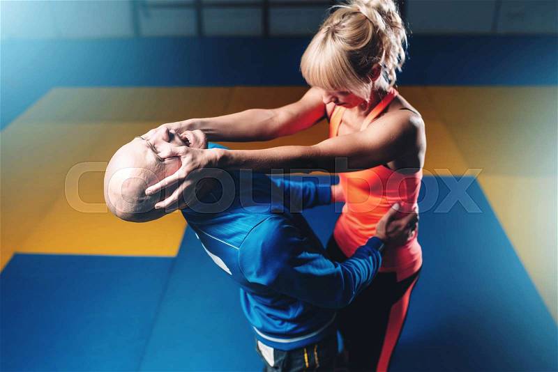 Women self defense technique, workout with personal instructor in gym, martial art, stock photo