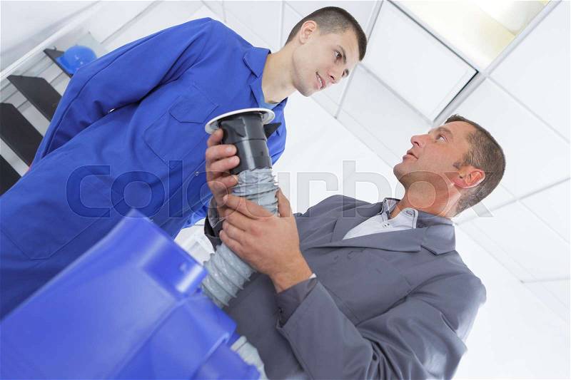 Ac technician teacher shows student how to install it, stock photo