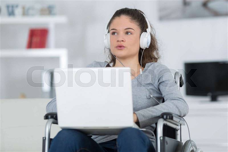 Disabled handicapped girl with laptop computer, stock photo