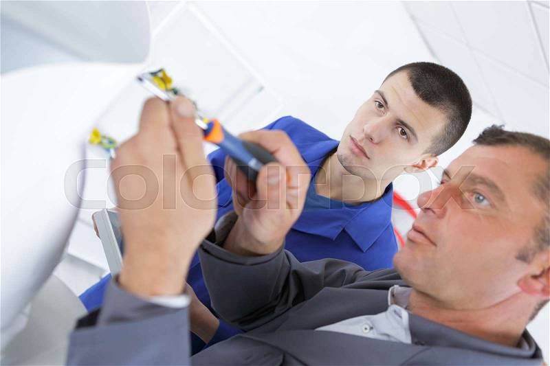 Student in electrical engineering course training with teacher, stock photo