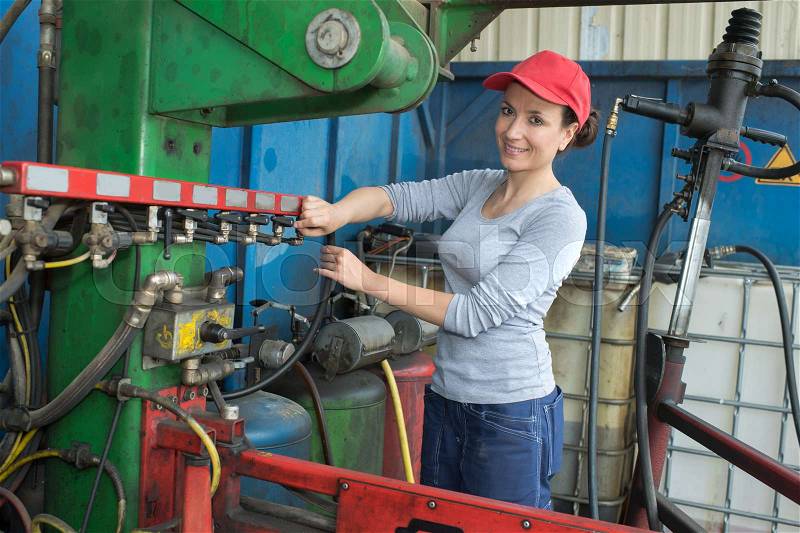 Young sexy brunette woman working as industrial mechanic, stock photo