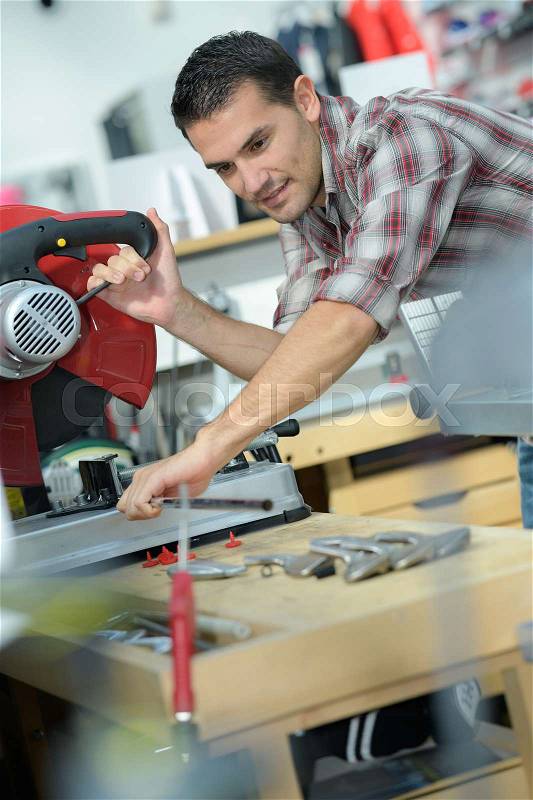 Happy male carpenter working in carpentry shop, stock photo