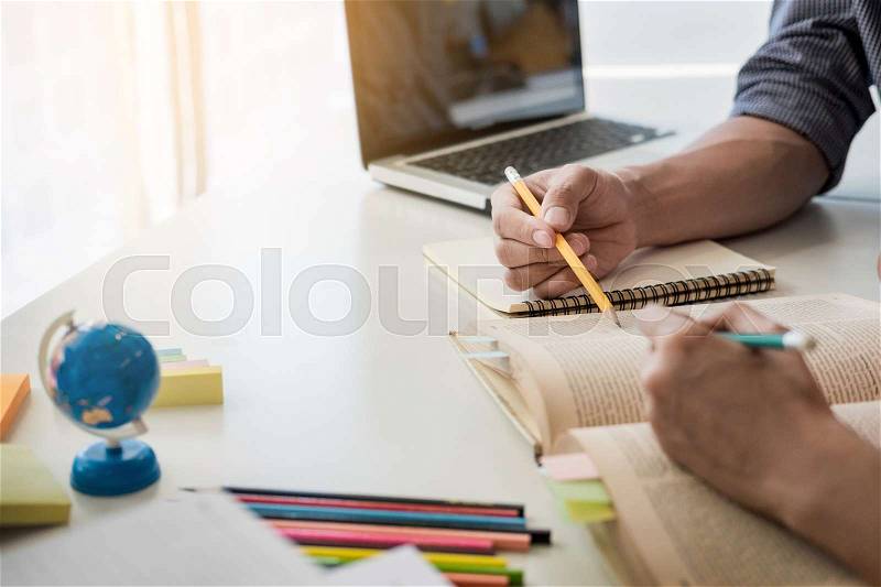 Young woman and man studying for a test/ an exam. Tutor books with friends. Young students campus helps friend catching up and learning. People, learning, education and school concept, stock photo