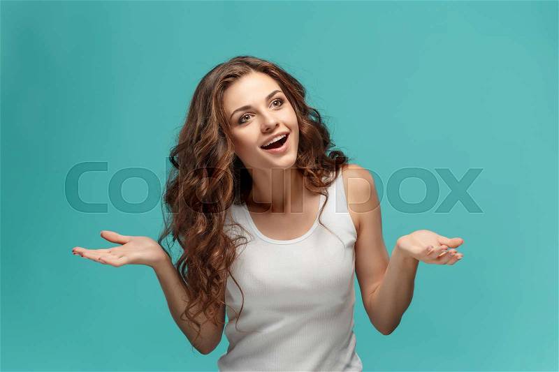 The young woman\'s portrait with happy emotions on blue background, stock photo