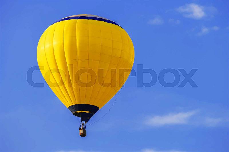 Yellow balloon in blue sky, stock photo