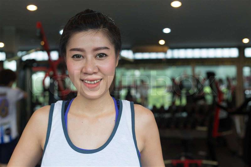 Close-up beautiful face portrait asian woman happy smile in fitness gym exercise workout sport club center, female wellbeing healthy lifestyle of city life, stock photo