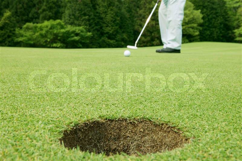 Man putting in a game of golf, stock photo