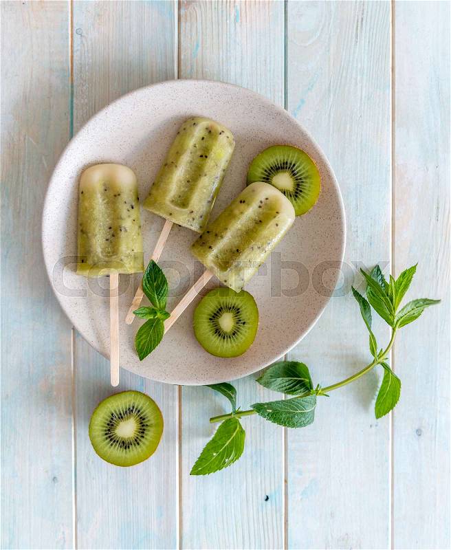 Plate of homemade ice cream with kiwi, some mint leaves, topview, stock photo