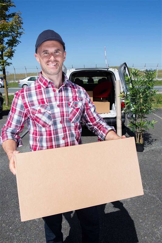Smiling man holding parcel, stock photo