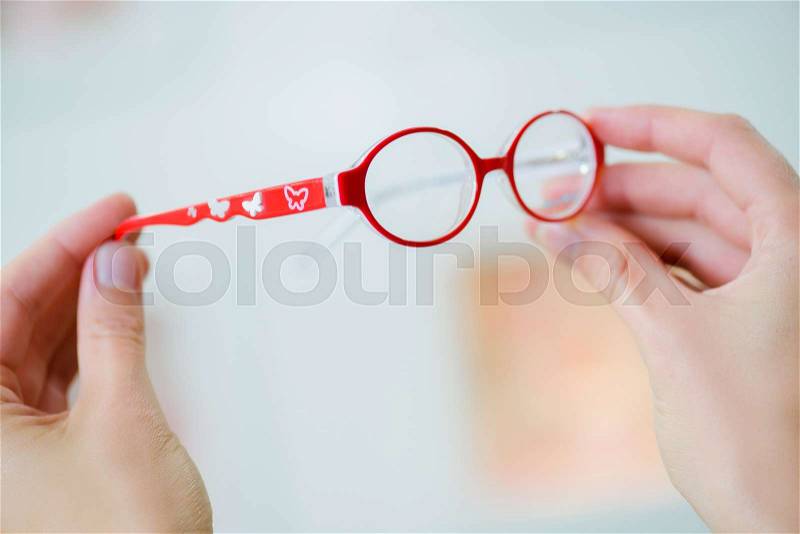 Woman holding vintage red glasses, stock photo