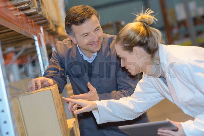 Workers choosing can with protective furniture oil in household section, stock photo