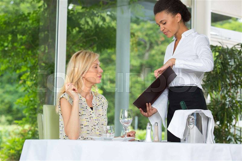 Woman ordering at the restaurant waitress writing the order, stock photo