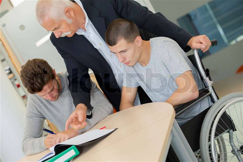 Man lecturing students in a university lecture theatre, stock photo