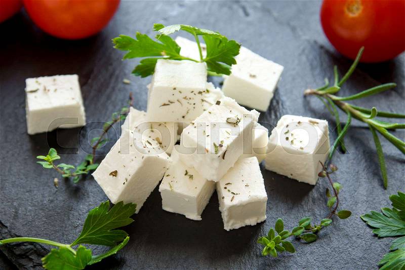 Fresh Greek Feta Cheese. Healthy ingredient for cooking salad. Goat feta cheese with herbs, stock photo
