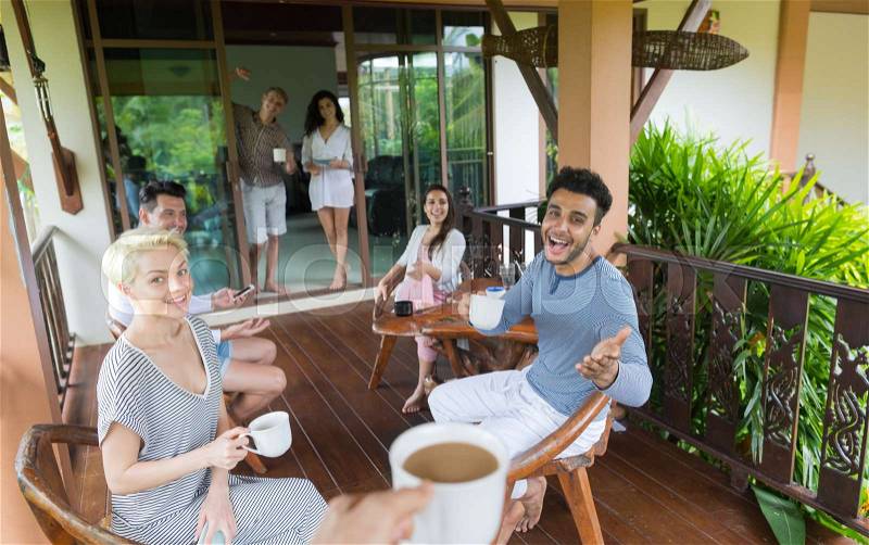 Young People Group Having Breakfast On Terrace Tropical Hotel, Friends Tropic Holiday Vacation Green Forest, stock photo