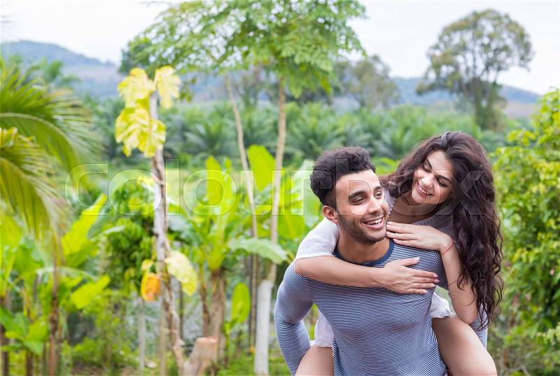 Happy Latin Man Carry Woman On Back, Young Couple Over Green Tropical Rain Forest Landscape Smiling Lovers Having Fun, stock photo