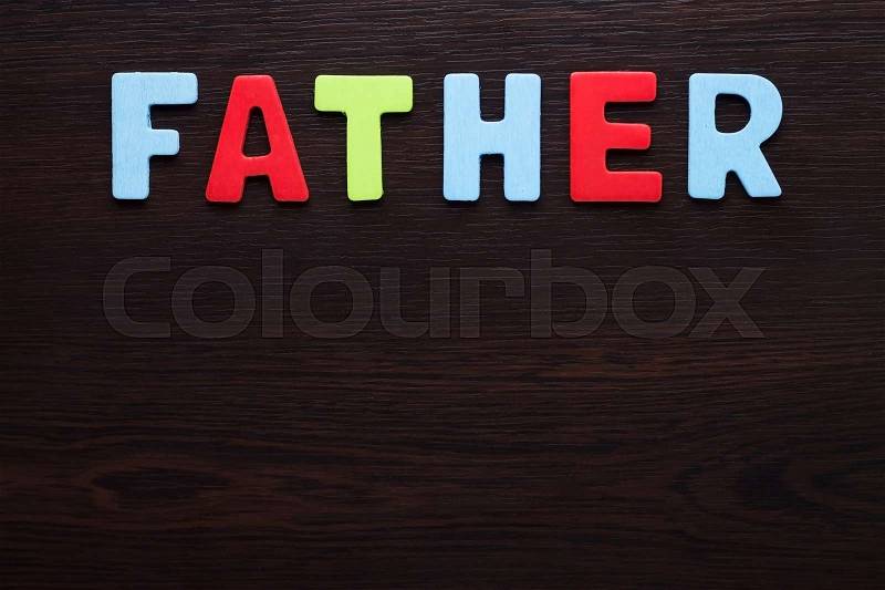 Father colorful letters on dark brown background, stock photo