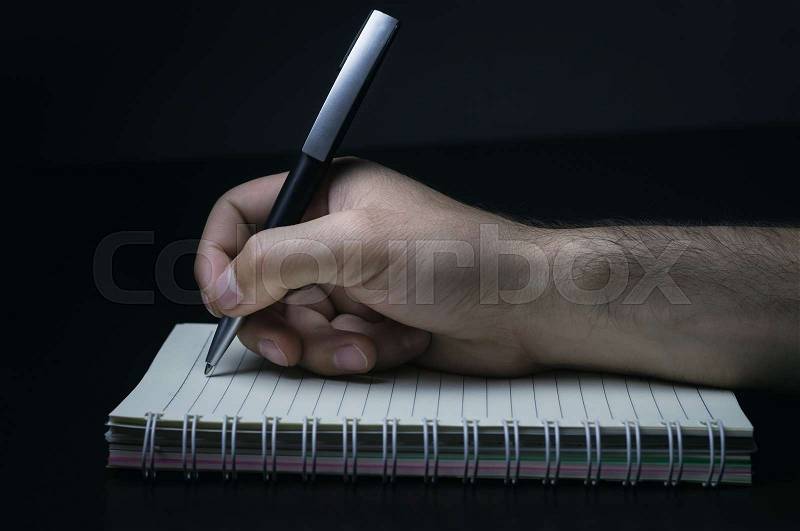 Hand writing with pen on notebook, stock photo