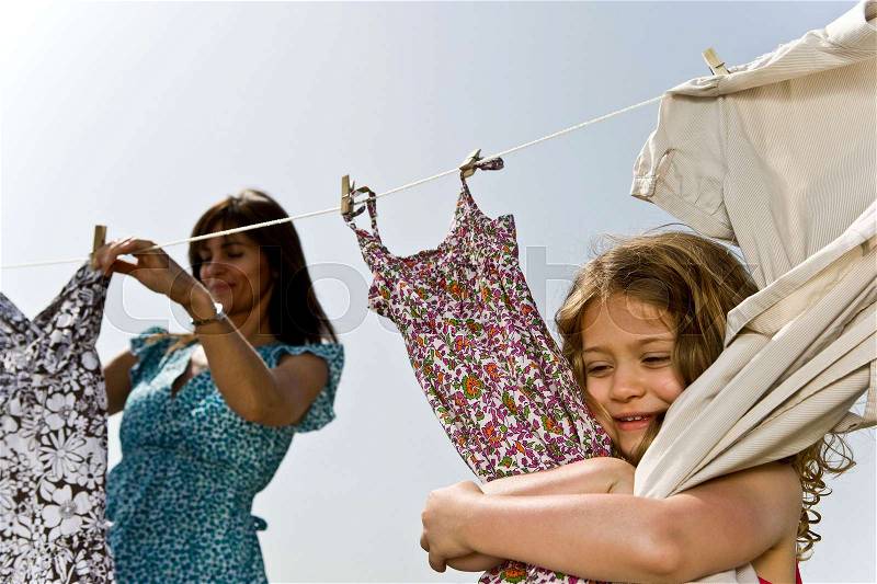 Girl hugging clothes on line, stock photo