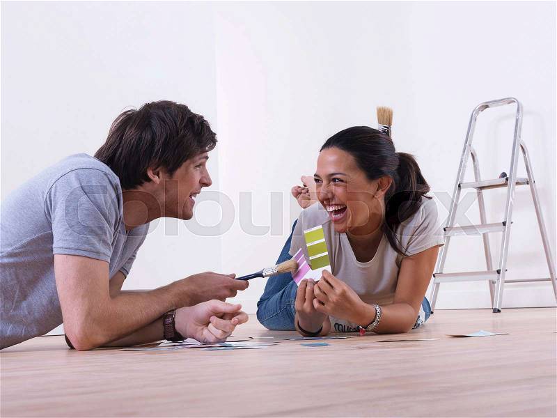 Couple choosing paint colours, stock photo