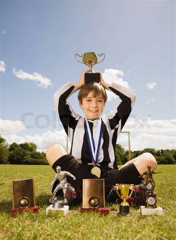 Boy footballer with Trophies and medals, stock photo