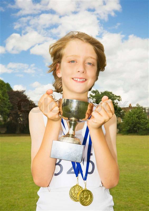 Boy athlete with trophy and medals, stock photo