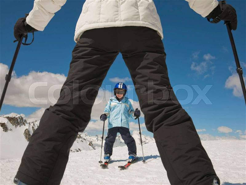 Woman teaching boy to ski, stock photo