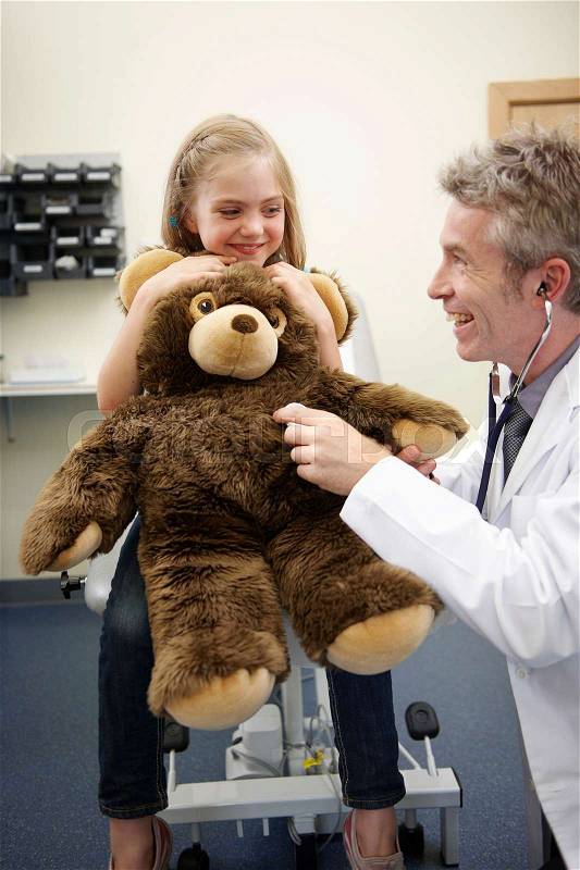 Doctor listening to teddy bear\'s heart, stock photo