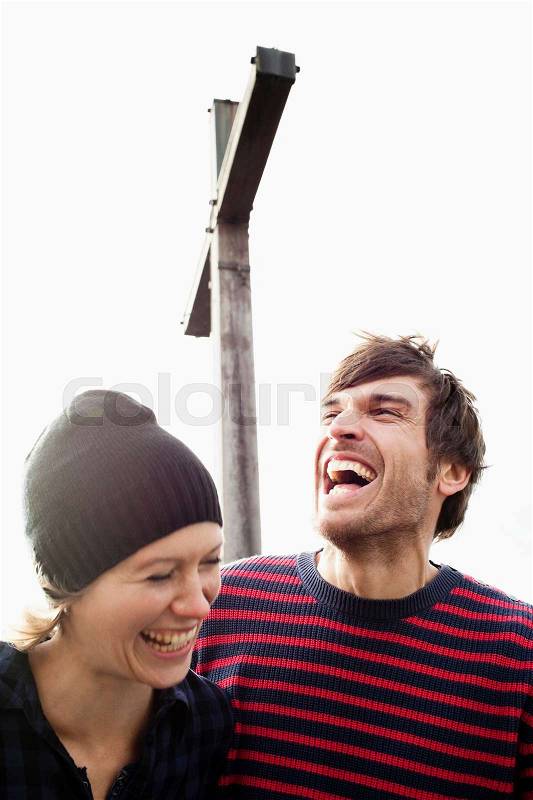 Couple laughing under mountain cross, stock photo