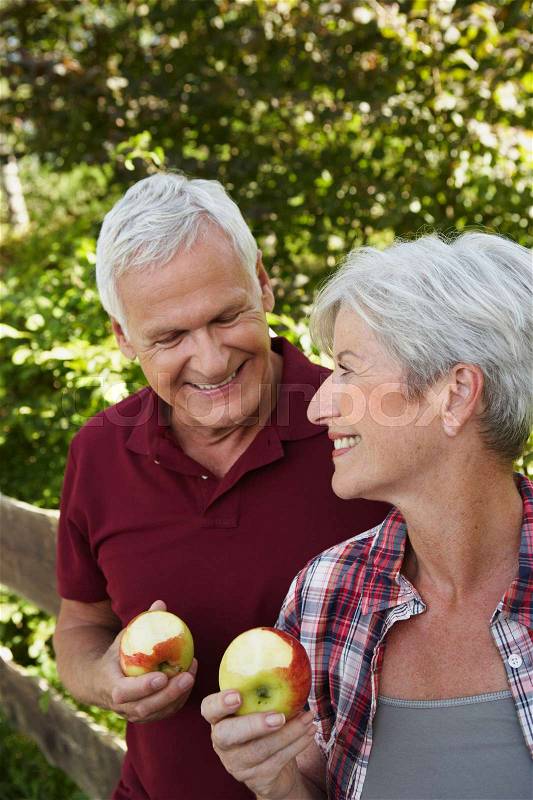 Senior couple eating apples, stock photo