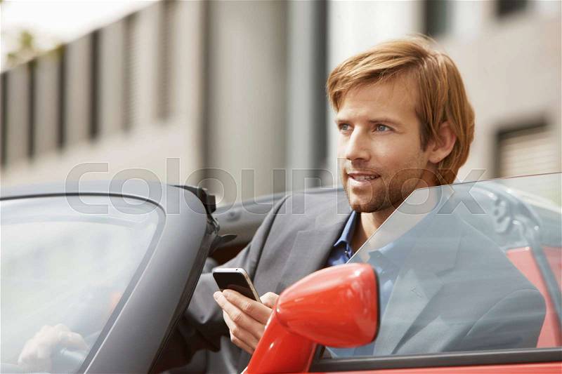 Business man on phone in an electric car, stock photo
