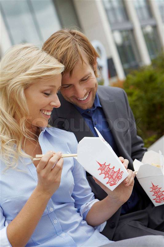 Couple eating chinese takeaway for lunch, stock photo