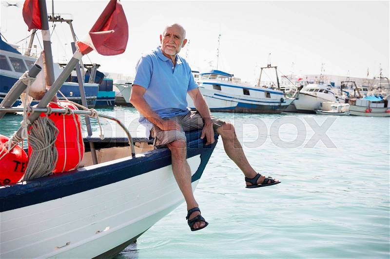 Fisherman sitting on boat, stock photo
