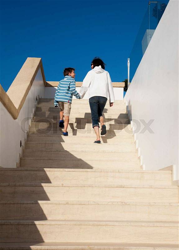 Mother and son walking up steps, stock photo