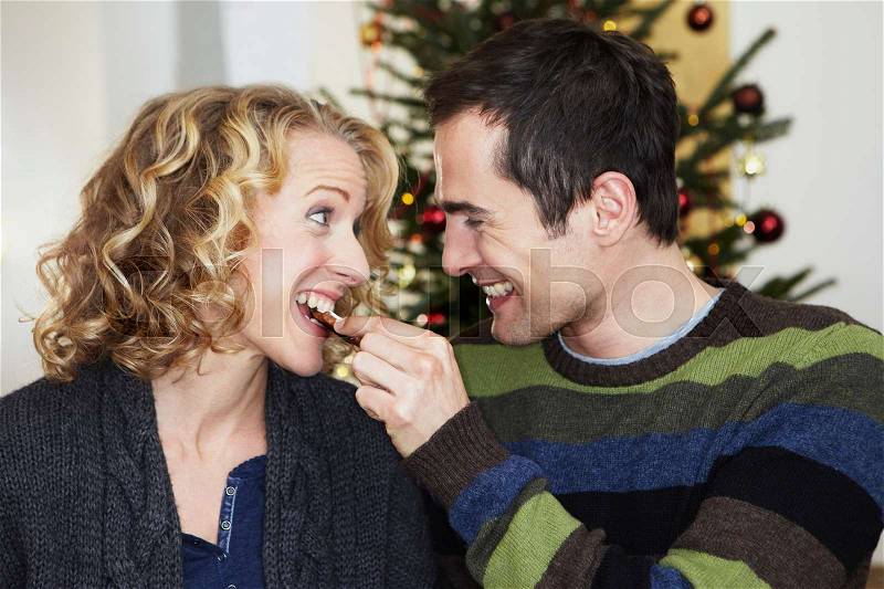 Man feeding woman with cookie, stock photo