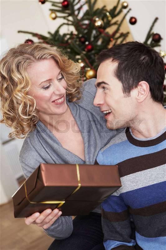 Woman presenting man a gift, stock photo