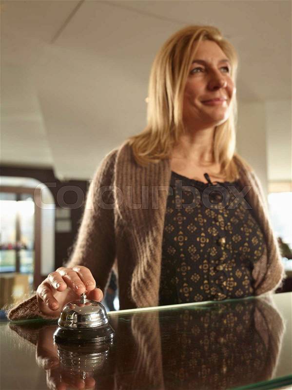 Woman ringing a hotel porters bell, stock photo