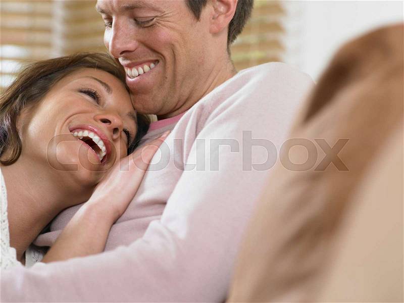 Laughing couple hugging, stock photo