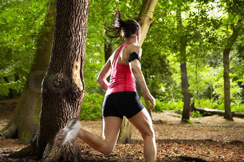 Woman running in forest, stock photo
