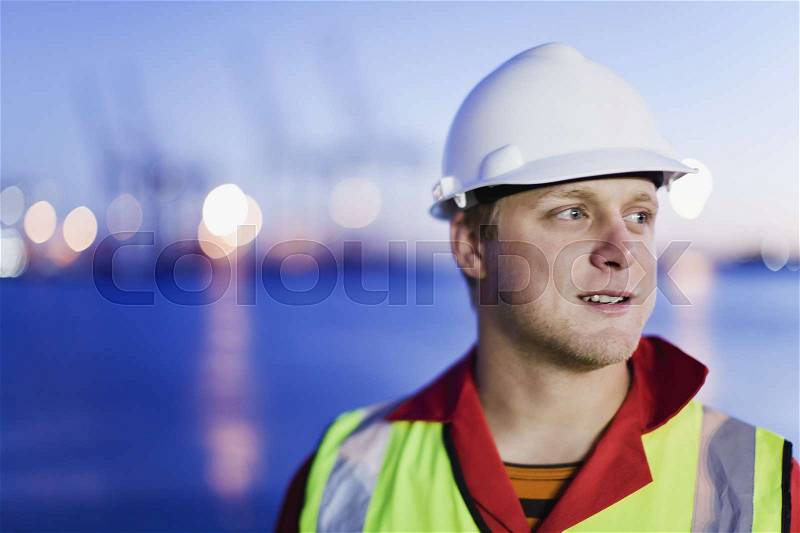Worker wearing hard hat in shipyard, stock photo