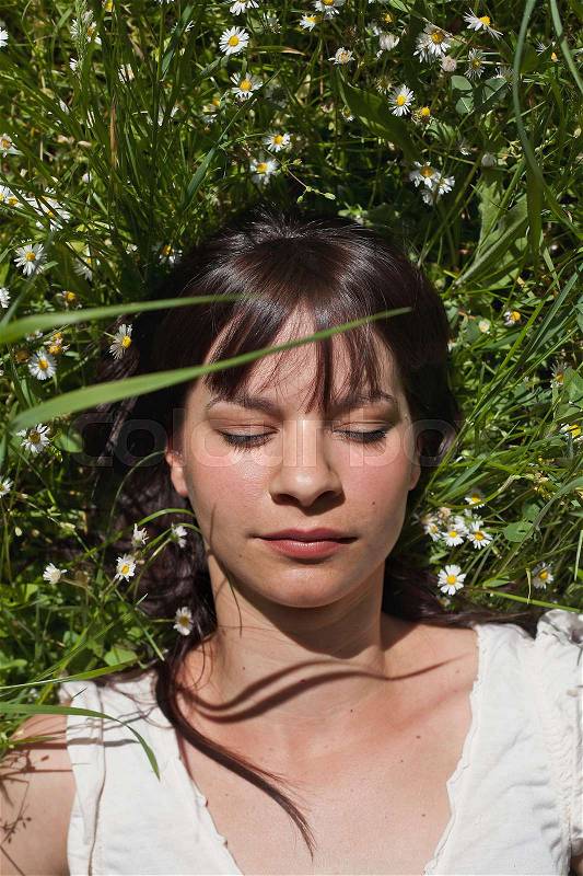 Woman asleep in tall grass, stock photo